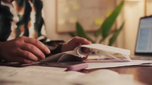 Woman sorts receipts using a calculator to track expenses at home. Budget planning or tax.