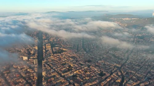 Aerial Drone Helicopter Barcelona City above the clouds and fog, typical buildings of Barcelona city