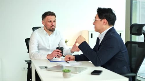 Two Businessmen Having a Discussion in a Modern Office
