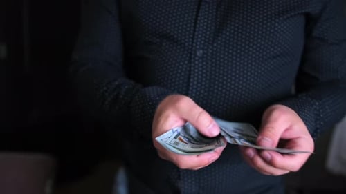 Person Counting Stack of Hundred Dollar Bills