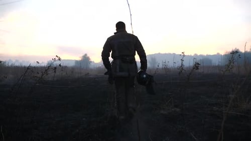 Firefighter Walking Through Field After Fire