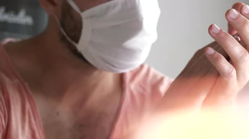 Man with beard wearing protective face mask and shaking his head, close up interior shot