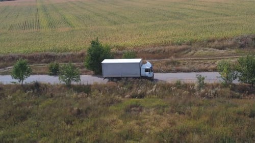 Aerial Shot of Truck with Cargo Trailer Driving on Road and Transporting Goods Flying Over Delivery