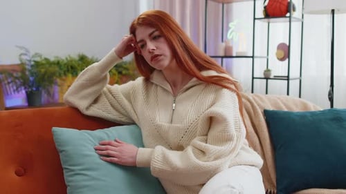 Woman with Red Hair Thinking on Couch