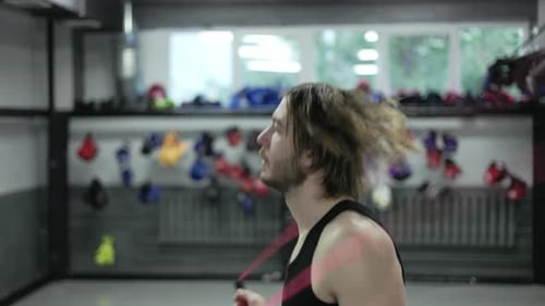 Side View of Bearded Man Jumping with Skipping Rope on Blurred Background