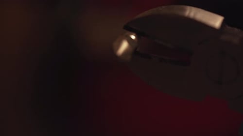 close-up of a 3D printing nozzle that is being held by tweezers