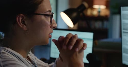 Woman Concentrating on a Computer at Home at Night