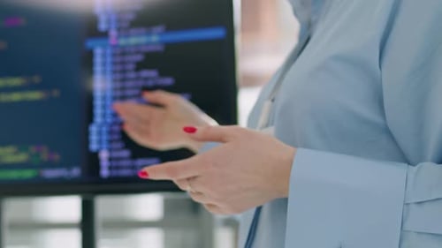 Woman Explaining Code on Computer Screen