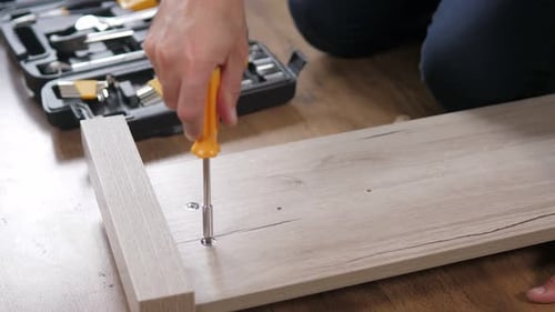 Adult Assembling Furniture with Screwdriver Close Up