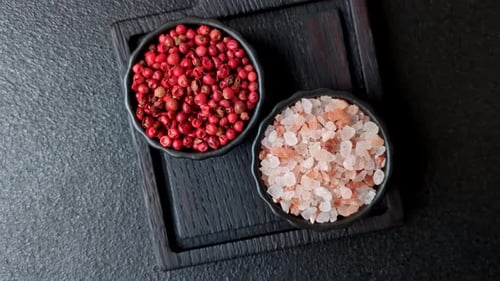Pink Peppercorns and Himalayan Salt on Black Board