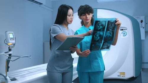 Neurodoctors Negotiating in Medical Clinic Office Discussing MRI Scan of Patient for Diagnostics