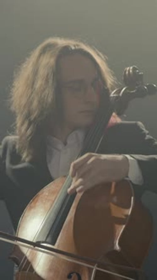 Vertical of Musician in Suit Playing Cello on Black Background