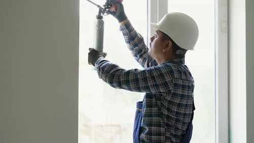 Indian Worker is Applying Polyurethane Foam to Fill Gap Between Sash and Window Frame