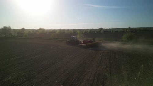 Green tractor works on the field sowing sunflower. Tractor planting corn in Ukraine