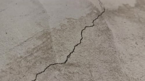 Close up of one long crack in concrete foundation in basement from settling home