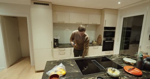 Man Using Smartphone in Modern Kitchen