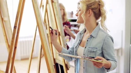 Art School Creativity and People Concept - Group of Students with Easels