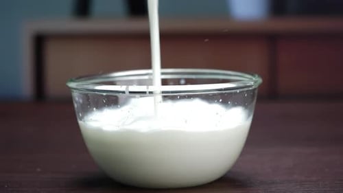A bowl of milk on a table, milk being poured into a glass bowl, and milk being poured into a bowl