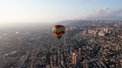 Hot air balloon above Haifa bay and Downtown area at sunrise, Aerial view