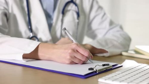 Doctor Writing on Clipboard in Office Setting
