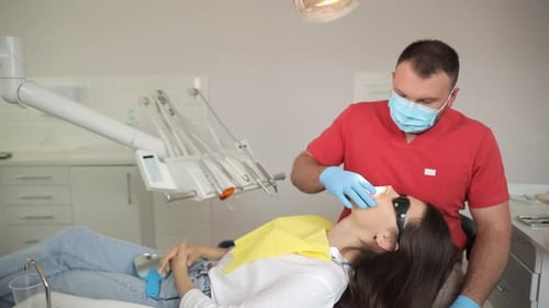 The Process of Whitening the Teeth of a Young Woman Doctor During Treatment and Teeth Whitening