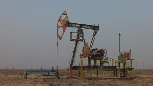 Pumping Petroleum Rig in Desert at Sunset Oil Industry Pump Jack Extracting Crude Oil From a Oil