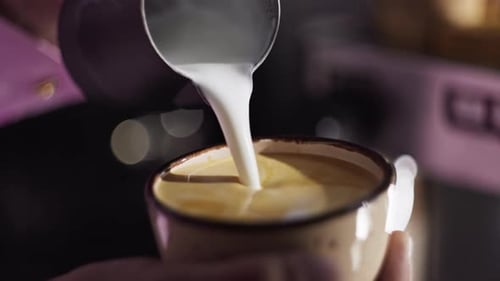 Closeup of Pouring Milk Into Coffee in a Cafe