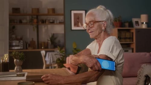 Elderly Caucasian Woman with Diabetes Checking Glucose with Smartphone App