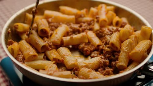 Delicious Rigatoni Pasta with Meat Sauce being Stirred
