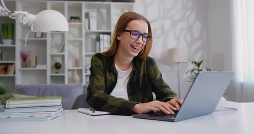 Woman Works on Laptop at Desk at Home