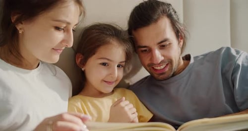 Family Reading Book Together Indoors During Daytime