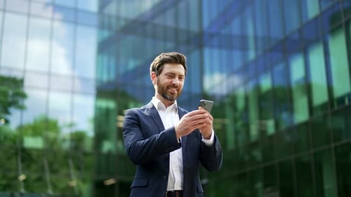 Man in Suit with Mobile Phone Outside Office