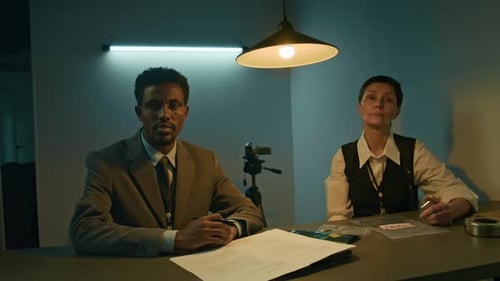 Detectives Reviewing Evidence in Police Interrogation Room