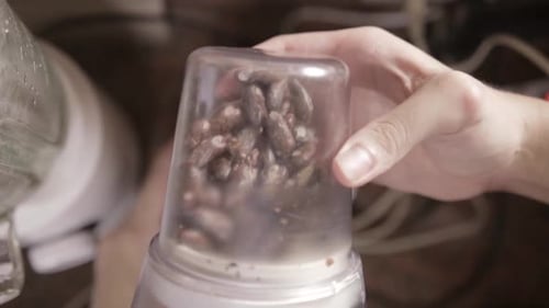 Close-up Top View of Coffee Beans Finely Grounding in Coffee Blade Grinder