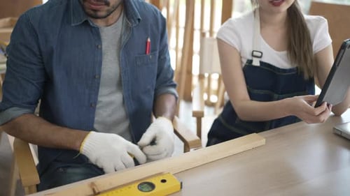 Carpenters are working at woodshop.