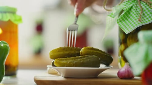 Appetizer, housewife professional movement Pickled cucumbers Hand holding fork in the home