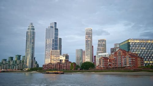 View of London from a floating boat on the Thames River at sunset, United Kingdom. Skyscrapers and m