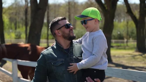 Loving Father and Son High Five near Horses
