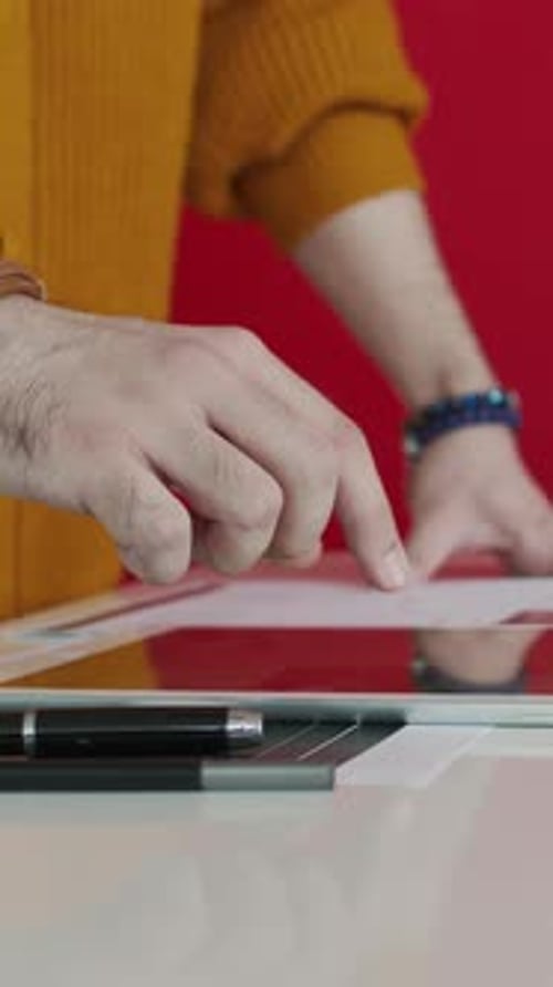 Die Hand eines anonymen Mannes surft im Creative Office auf dem Tablet