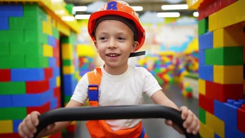 Child Wearing a Hard Hat Smiling and Moving