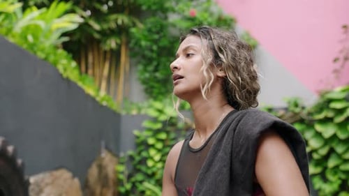 Woman Wipes Sweat and Drinks Water After Tropical Workout