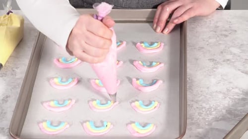 Step By Step Piping Meringue Mix Into Unicornshaped Pops on a Baking Sheet Lined with Parchment