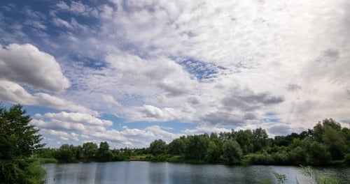 White Cumulus Clouds Float Over the River