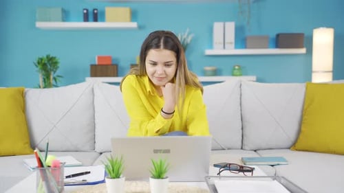 Young Woman Working on Laptop at Home on Couch