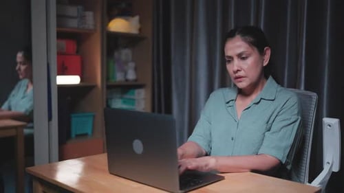 Woman Working on Laptop Late at Night