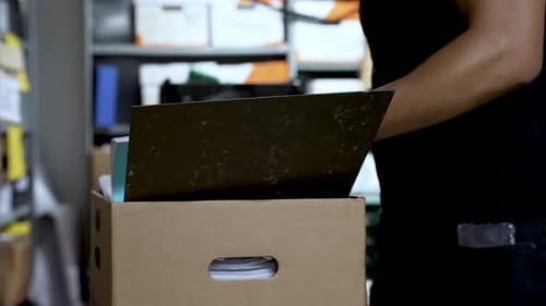 Adult Removing Documents from a Cardboard Box