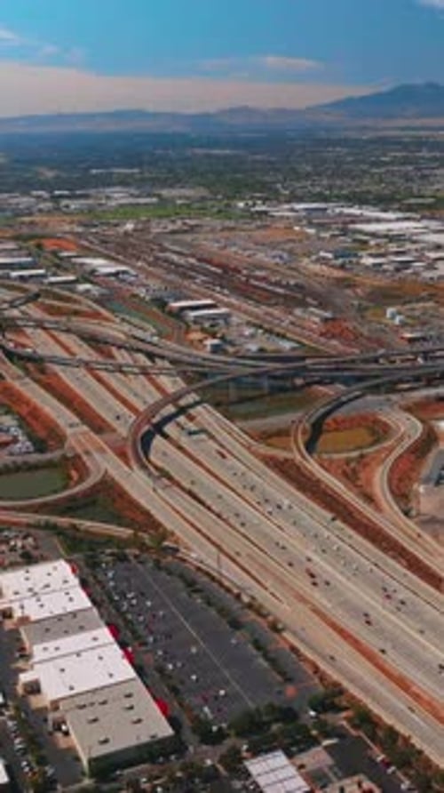 Multi-lane roads and flyovers in the industrial area. Green residential part of the city