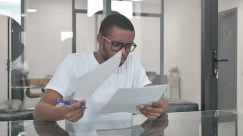 Man Reviews Documents in Modern Office