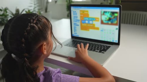 Hispanic Kid Girl Student Learning at Home to Program a Video Game. STEAM, Mathematics Engineering S