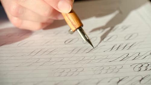 Calligrapher Writing Cursive Letters with Dip Pen